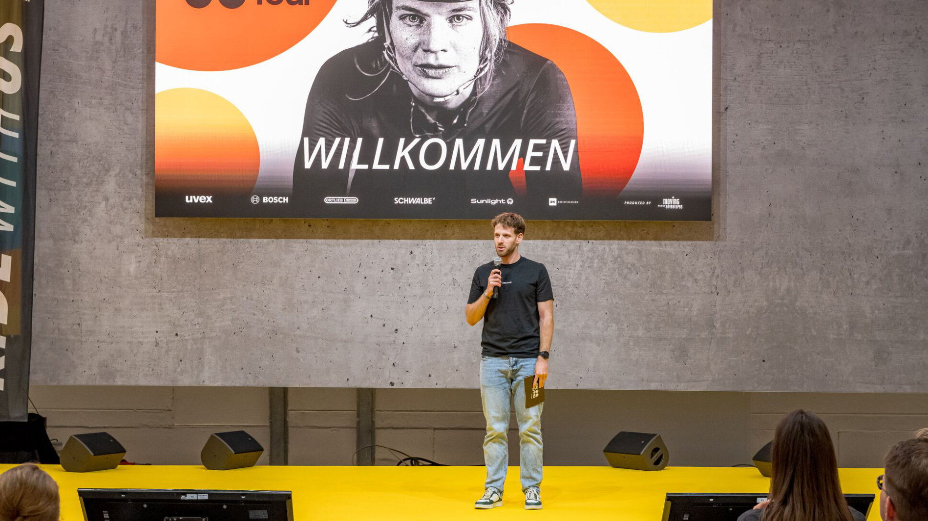 Sprecher auf Bühne vor Willkommen-Banner bei EUROBIKE