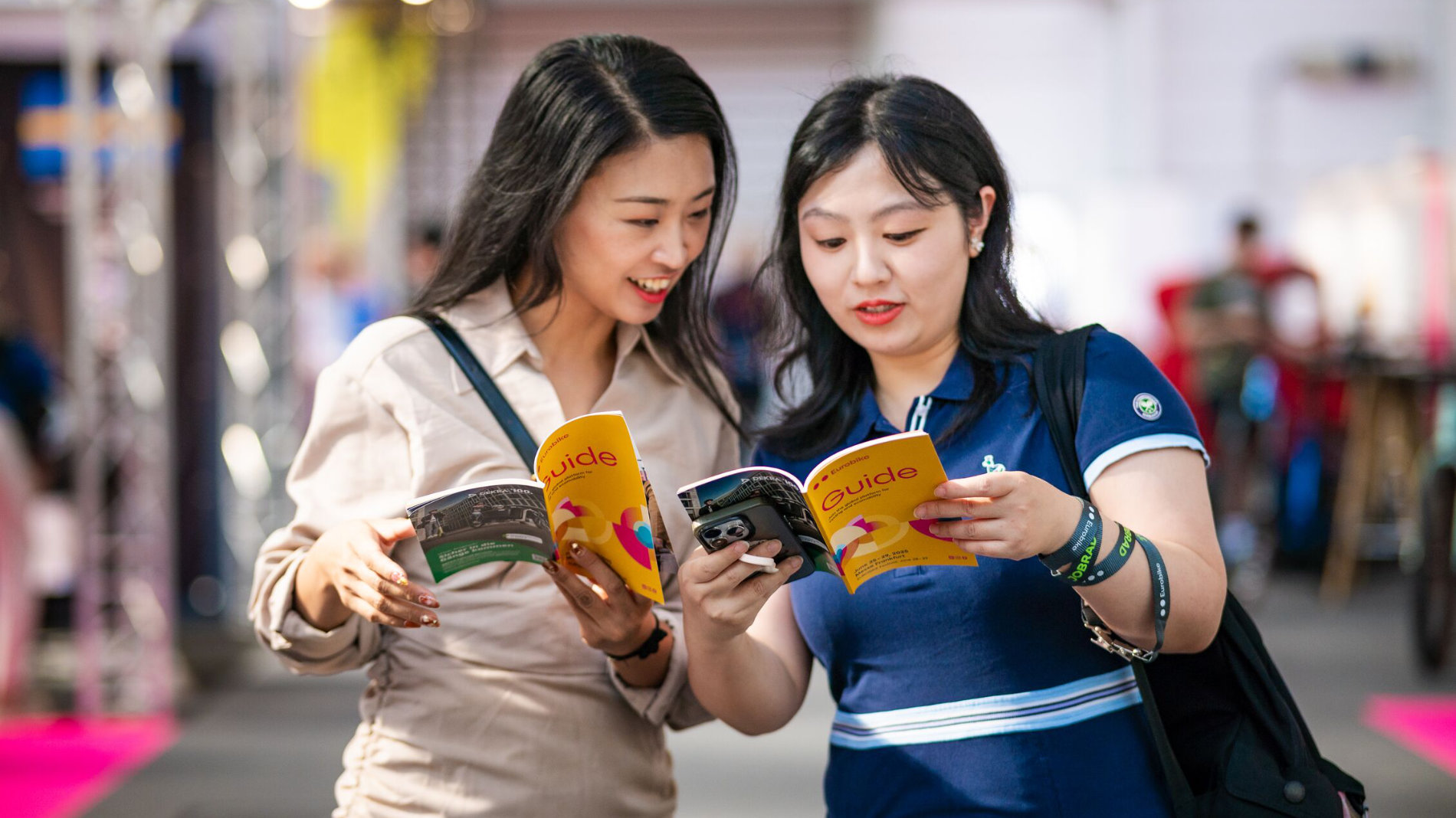 Visitors reading EUROBIKE Guide at exhibition venue