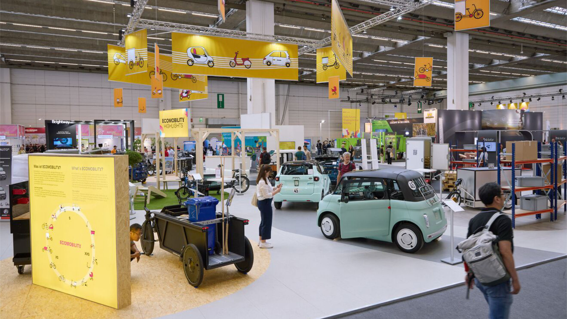 Messehalle mit Ecomobility-Ständen und Fahrzeugen