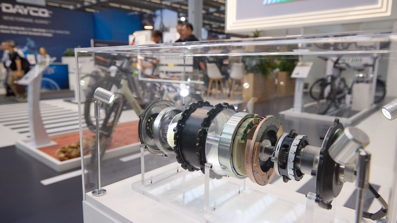 Technical exhibit of a disassembled drivetrain system displayed in a showcase.