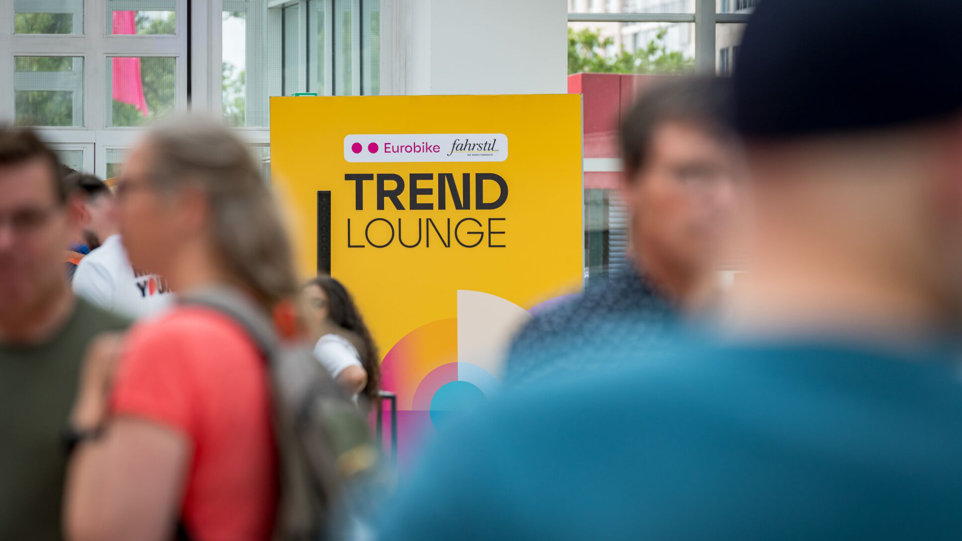 Visitors moving past a yellow “Trend Lounge” sign at the exhibition venue.