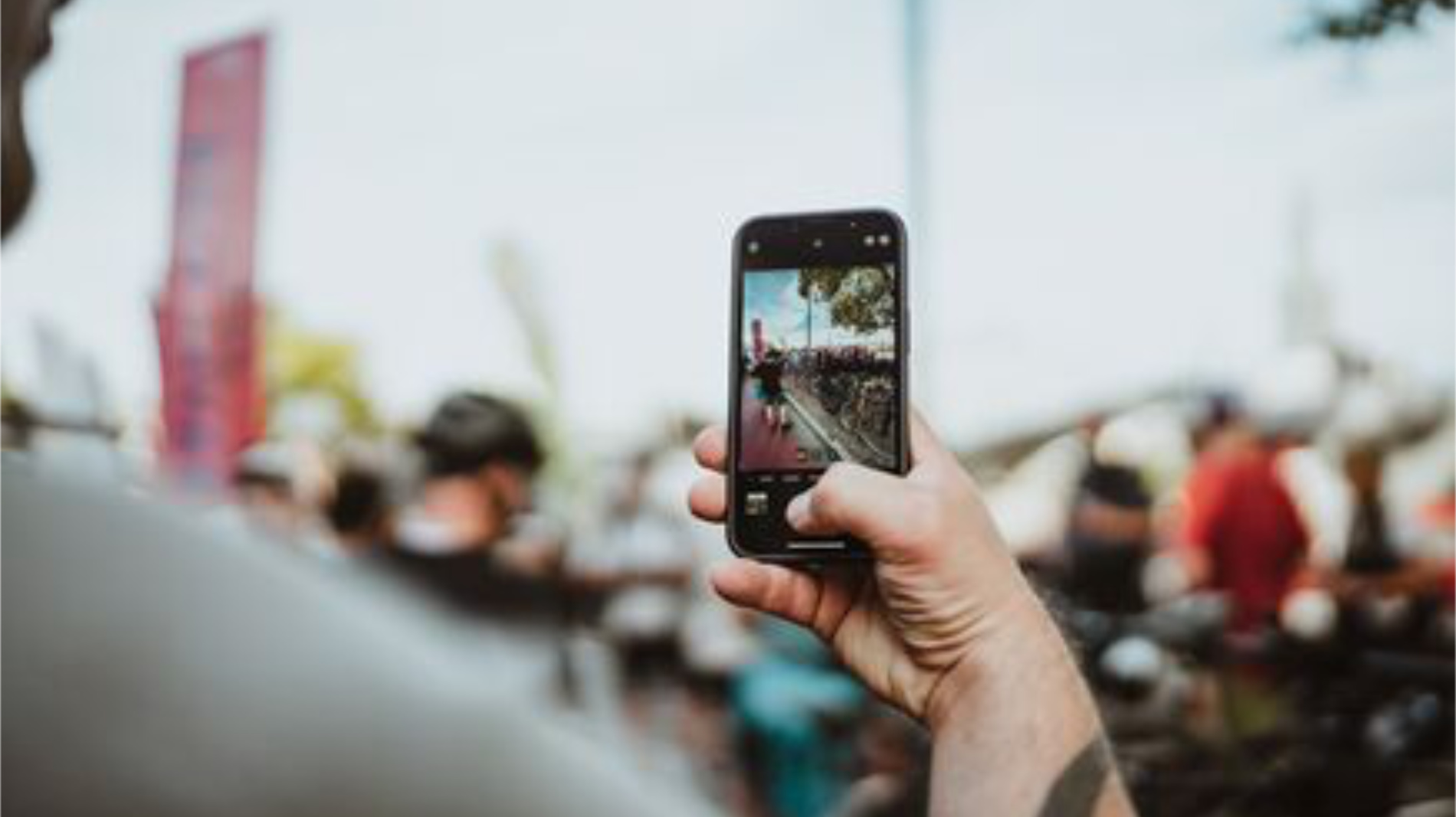 Visitor taking photo at cycling event with smartphone