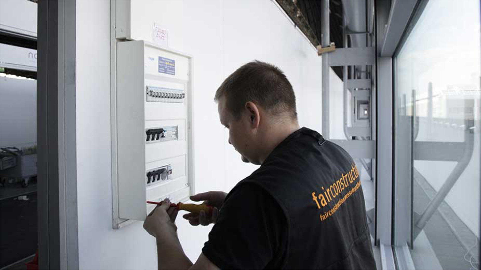 Elektriker prüft Stromverteiler im Messegebäude