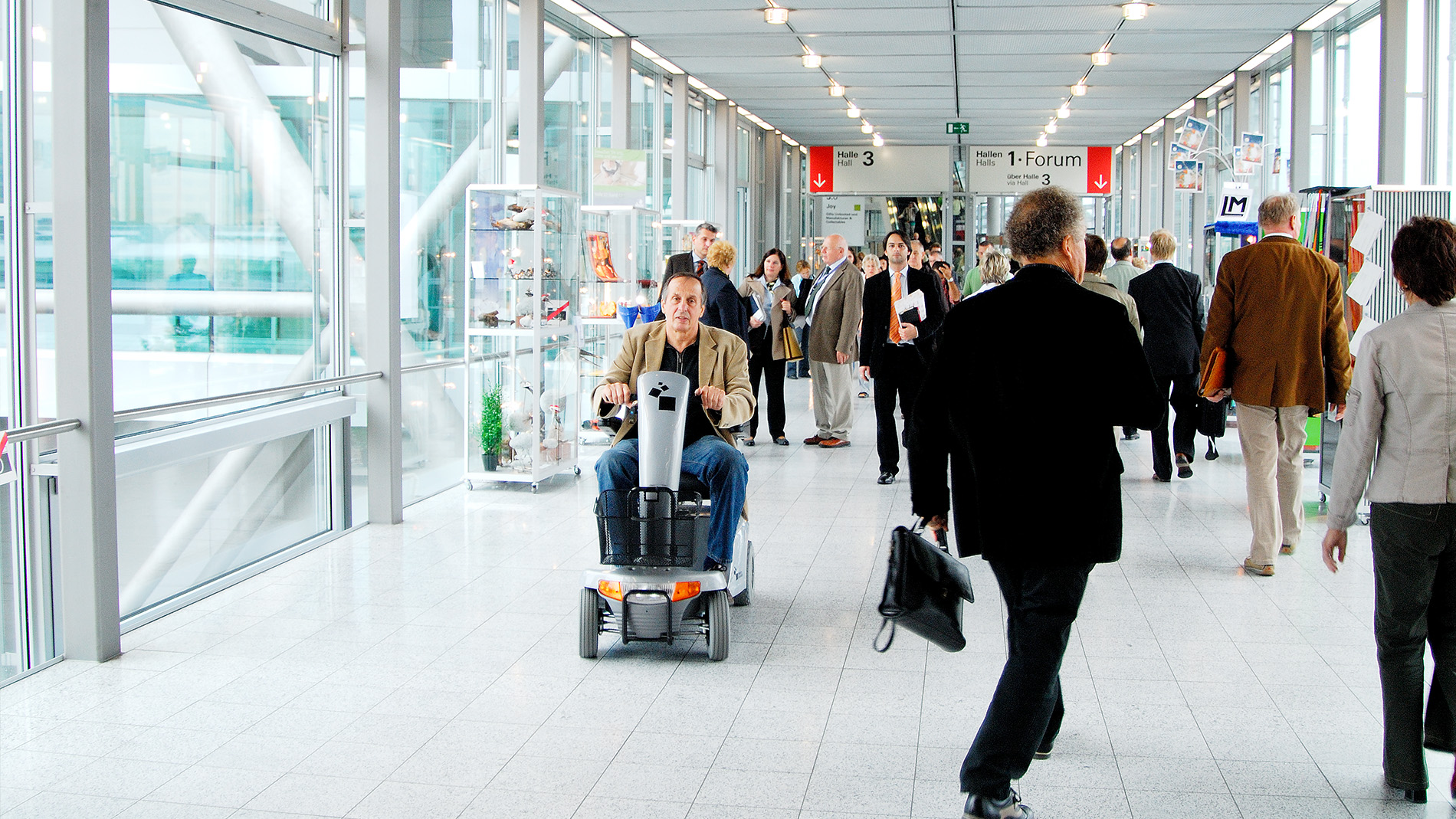 Visitor travelling through exhibition corridor on mobility scooter